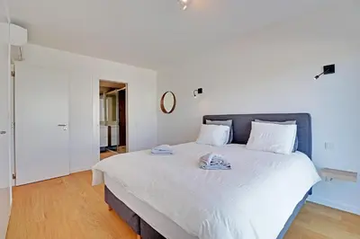 a bedroom with a large white bed with towels on it at Apartamento Vista Jardim by Portucasa in Albufeira