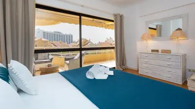 a bedroom with a large bed with a large window at Marina 2BDR Apartment With Balcony & Pool - 5min from beach by LovelyStay in Quarteira