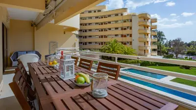 a wooden table on the balcony of a apartment at Marina 2BDR Apartment With Balcony & Pool - 5min from beach by LovelyStay in Quarteira