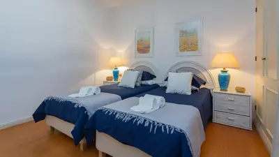 a bedroom with two beds with blue and white sheets at Marina 2BDR Apartment With Balcony & Pool - 5min from beach by LovelyStay in Quarteira