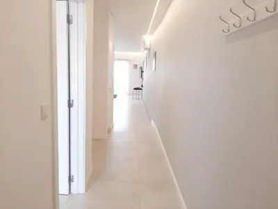 a hallway with white walls and a white floor at Apartamento Max Tropical by Sunnyway in Albufeira