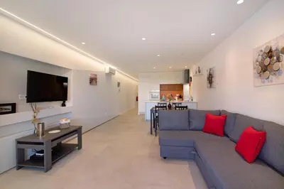 a living room with a blue couch and red pillows at Apartamento Max Tropical by Sunnyway in Albufeira