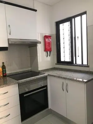 a kitchen with a stove and a window in it at Bmar in Quarteira