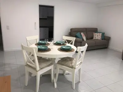 a white dining room table with chairs and a couch at Bmar in Quarteira