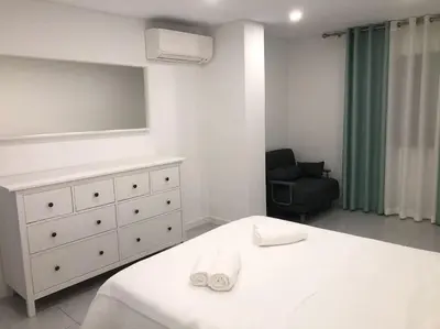 a bedroom with a bed and a dresser and a chair at Bmar in Quarteira
