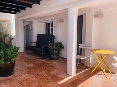 a living room with a chair and a table at Old Fisherman's Corner 10 - Centro Old Town Albufeira in Albufeira