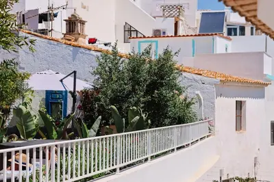 a white balcony with plants and buildings at Old Fisherman's Corner 12 - Centro Old Town Albufeira in Albufeira