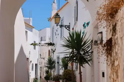 an alley with white buildings and a palm tree at Old Fisherman's Corner 12 - Centro Old Town Albufeira in Albufeira