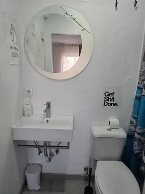 a bathroom with a toilet and a sink and a mirror at Guest House Casa Ramos on the Strip in Albufeira