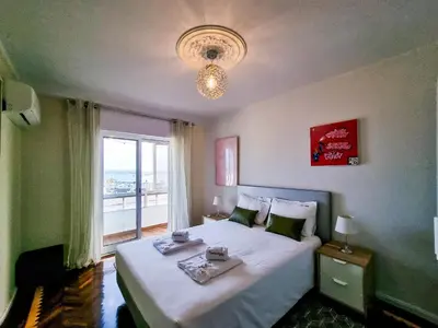 a bedroom with a large bed and a window at FLH Faro Family Flat with Balcony in Faro