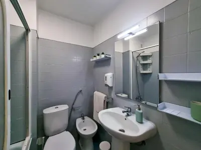 a bathroom with a sink and a toilet and a mirror at FLH Faro Family Flat with Balcony in Faro