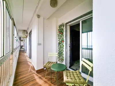 a hallway with a green chair and a window at FLH Faro Family Flat with Balcony in Faro