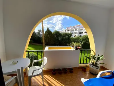 a balcony with an arched window and a table and chairs at CASA IRINA Centro Cidade Albufeira in Albufeira
