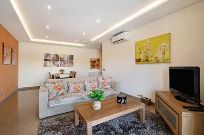 a living room with a couch and a tv at Varandas do Sol - Olhos de Água in Albufeira
