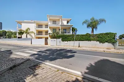 an empty street in front of a large building at Varandas do Sol - Olhos de Água in Albufeira