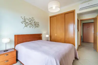 a bedroom with a bed and a dresser with a tv at BnB Homes Ocean view Apartment with panoramic Terrace, 2 Swimming pools & Tennis court in Albufeira