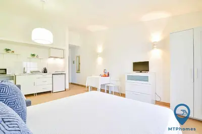 a living room with a couch and a kitchen at Estúdio Solar A by MTPhomes in Albufeira