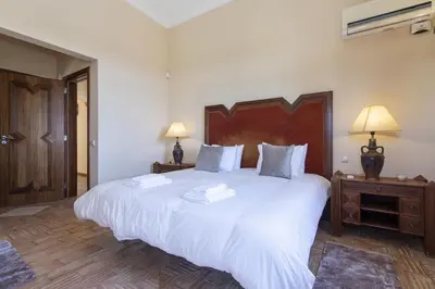 a bedroom with a large bed with white sheets and pillows at Quinta Dionysus in Albufeira
