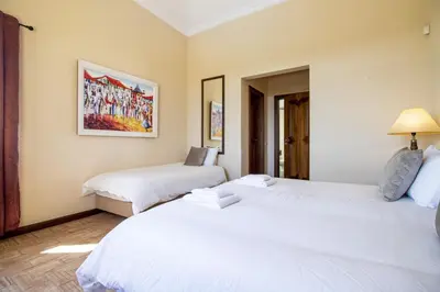 two beds in a room with white sheets at Quinta Dionysus in Albufeira