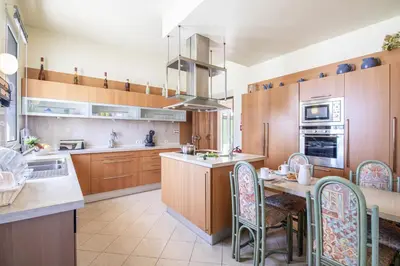 a kitchen with wooden cabinets and a table and chairs at Quinta Dionysus in Albufeira