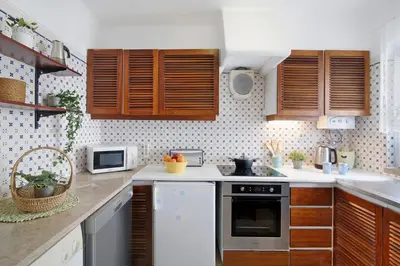 a kitchen with wooden cabinets and a stove top oven at Apartamento São Rafael in Albufeira