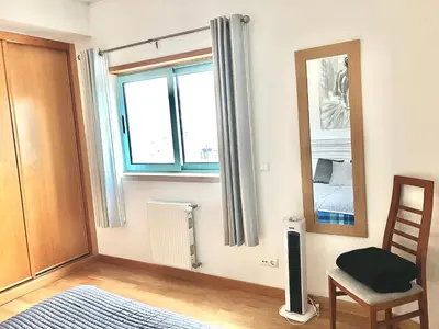 a room with a mirror and a chair and a window at Marina View Apartment in Albufeira