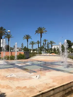 a fountain in a park with palm trees at Marina View Apartment in Albufeira