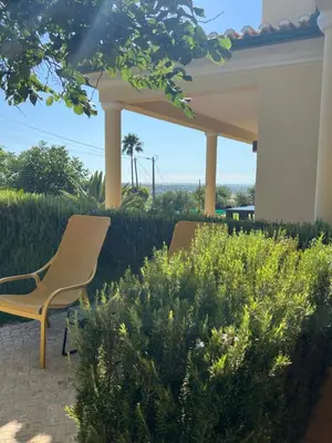 two chairs sitting under a gazebo in a garden at Villa Tranberg Suites in Ferreiras
