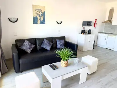 a living room with a black couch and a table at Apartment Les 3 Dauphins in Albufeira in Albufeira