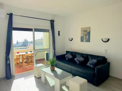 a living room with a black couch and a table at Apartment Les 3 Dauphins in Albufeira in Albufeira