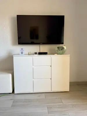 a white cabinet with a flat screen tv on a wall at Apartment Les 3 Dauphins in Albufeira in Albufeira
