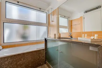a kitchen with white cabinets and a microwave oven at Terras Novas Village Albufeira in Albufeira