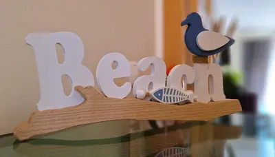 a wooden sign that says bake on top of a glass table at Sul House in Albufeira