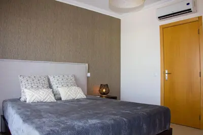 a bedroom with a bed and a wooden door at Sul House in Albufeira