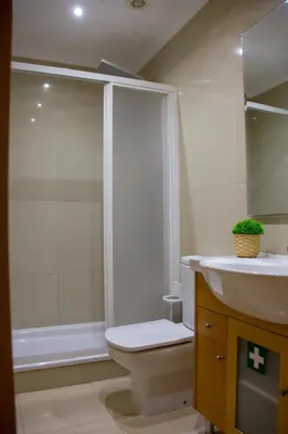 a bathroom with a shower and a toilet and a sink at Sul House in Albufeira