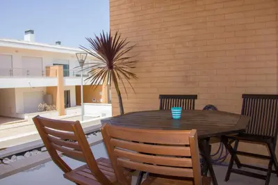 a wooden table and chairs on a patio at Sul House in Albufeira