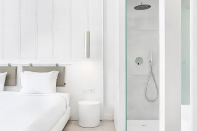 a white bathroom with a bed and a shower at Vila Maria Hotel - Adults Only in Albufeira