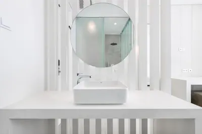 a white bathroom with a sink and a mirror at Vila Maria Hotel - Adults Only in Albufeira