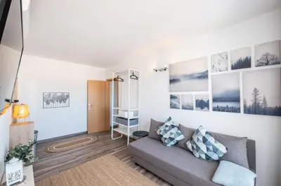 a living room with a couch and pictures on the wall at BeGuest Oceanic Rainbow Apt in Albufeira