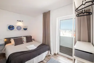 a bedroom with a bed and a large window at BeGuest Oceanic Rainbow Apt in Albufeira