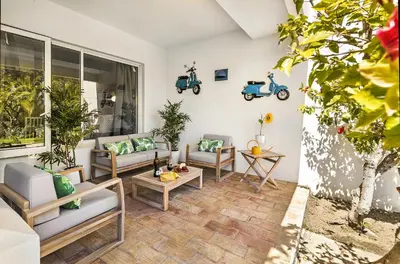 a patio with couches and scooters on the wall at Vista Portuguesa by OCvillas in Albufeira