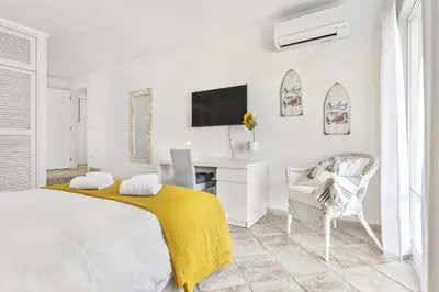 a white bedroom with a bed and a desk at Vista Portuguesa by OCvillas in Albufeira