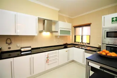 a kitchen with white cabinets and a bowl of oranges on the counter at Apartment Garcas Lounge - By Dalma Portuguesa in Albufeira