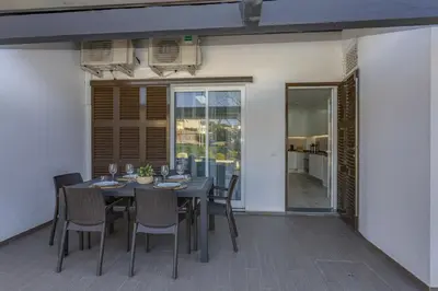 a dining room with a table and chairs on a patio at Vilar do Jardim - Terrace and Pool - Vilamoura in Quarteira