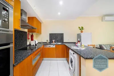 a kitchen with wooden cabinets and a dishwasher at Vista das Ondas 02B - Dream Lodging in Albufeira
