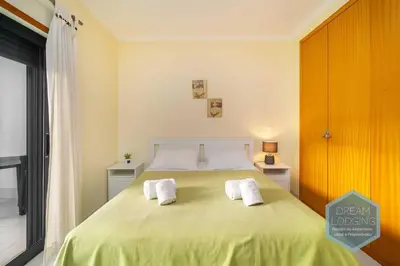 a bedroom with a large bed with two white towels at Vista das Ondas 02B - Dream Lodging in Albufeira
