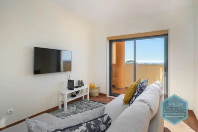 a living room with a couch and a flat screen tv at Oceanus Jardim - Dream Lodging in Albufeira