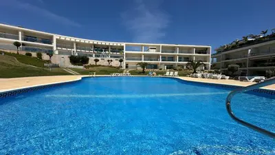 a table with food and a view of a building at Charmant appartement, calme avec vue piscine, 1km de la plage, Olhos de Água in Albufeira