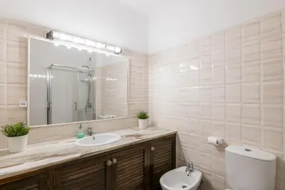 a bathroom with a sink and a toilet and a mirror at Sunny House Albufeira in Albufeira
