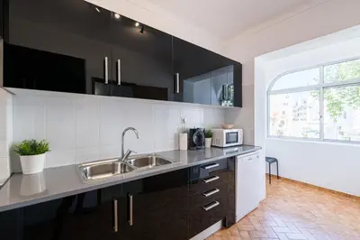 a kitchen with a sink and a microwave at Sunny House Albufeira in Albufeira